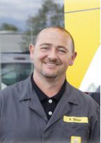 Klaus Distler im Arbeitskittel vor dem Autohaus